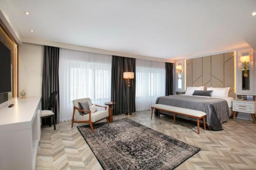 a hotel room with a bed and a couch and chair at Limak Eurasia Luxury Hotel in Istanbul