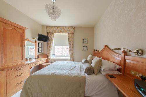 a bedroom with a bed and a desk and a window at Morston Hall in Holt