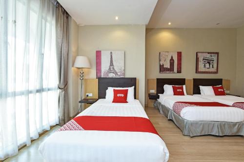 a bedroom with two beds with red and white sheets at Collection O Melaka Near Dataran Pahlawan Formerly Ideals Hotel in Melaka