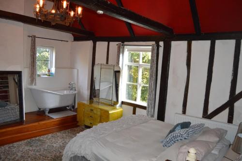 a bedroom with a bed and a tub and a sink at Countryside Tiny House in Roydon