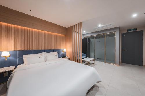 a bedroom with a large white bed in a room at Hotel Palace Gyeongju in Gyeongju