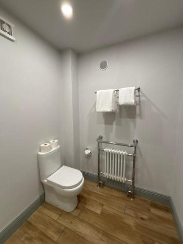 a bathroom with a toilet and a radiator and towels at The Fincourt B&B in Oldcastle