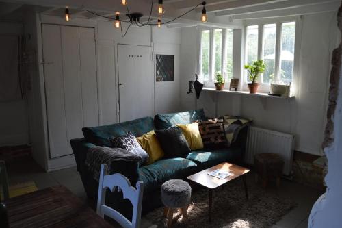 a living room with a blue couch and a table at Countryside Tiny House in Roydon