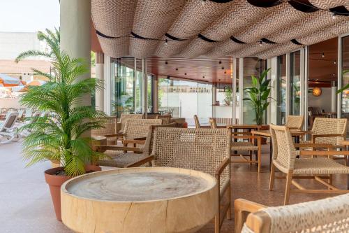 a restaurant with a round table and chairs and trees at tent Arenal in El Arenal