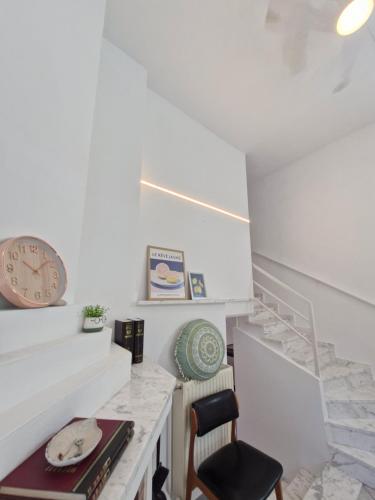 a room with a desk and a clock and stairs at Relax Dream Villa-House, Apartement, Studio in Kallithea Halkidikis