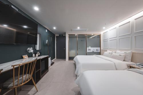 a hotel room with two beds and a couch at Hotel Palace Gyeongju in Gyeongju