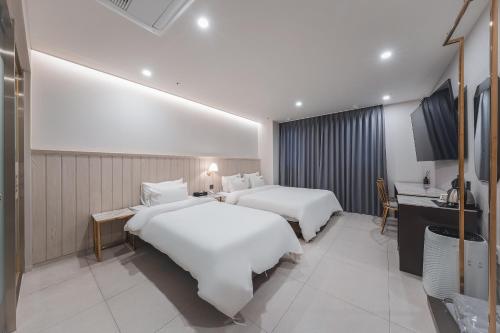 a hotel room with two beds and a kitchen at Hotel Palace Gyeongju in Gyeongju