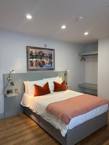a bedroom with a large bed with orange pillows at The Fincourt B&B in Oldcastle