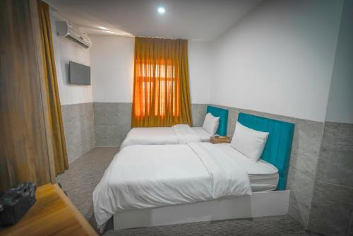 a bedroom with a large bed and a window at Danzha Hotel 2 in Erbil