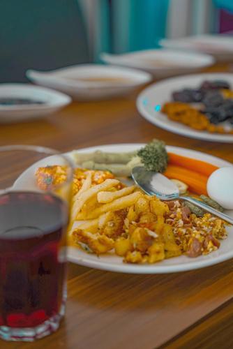 a table with a plate of food and a drink at Danzha Hotel 2 in Erbil