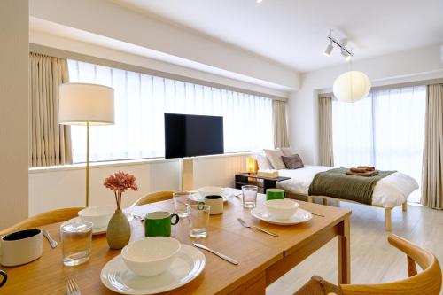 a living room with a table and a bed at Palaisgrace Shibuya - Live Like a Trendy Local in Sangenjaya 三軒茶屋 - Direct Shibuya Access in Tokyo