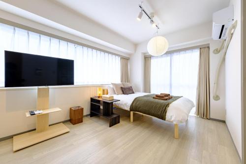 une chambre avec un lit et une télévision à écran plat dans l'établissement パレグレイス - Palaisgrace Shibuya, à Tokyo