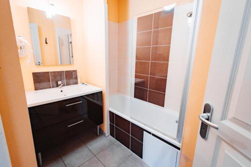 a bathroom with a sink and a shower at Vacancéole - Le Domaine de la Vallée d'Ax in Ax-les-Thermes