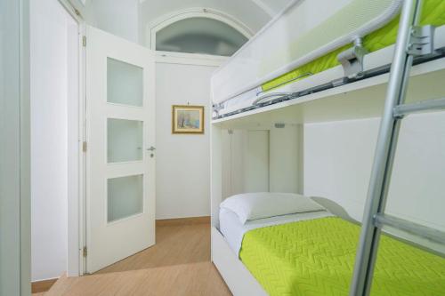 a bedroom with a bunk bed with a green blanket at Le Case Di Rosella in Vico Equense