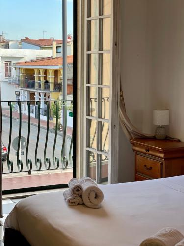 a bedroom with a bed and a large window at Gió guest house in La Caletta