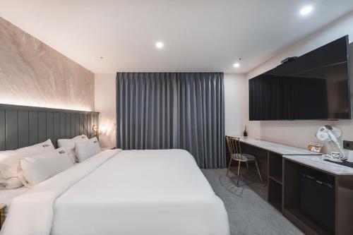 a hotel room with a large bed and a desk at Hotel Palace Gyeongju in Gyeongju