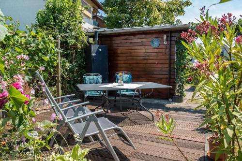 a patio with a table and chairs in a garden at Haus Gramespacher in Bad Bellingen