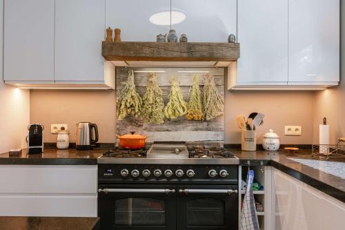 a kitchen with a black stove and white cabinets at Huswell - Lovely retreat for 2 in Antwerp in Antwerp