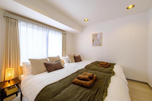 a bedroom with a large bed with two towels on it at Palaisgrace Shibuya - Live Like a Trendy Local in Sangenjaya 三軒茶屋 - Direct Shibuya Access in Tokyo