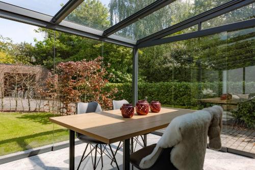 a glass conservatory with a wooden table and chairs at Huswell - Lovely retreat for 2 in Antwerp in Antwerp