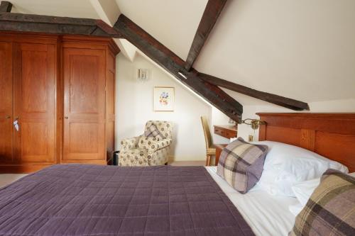 a bedroom with a large bed and a chair at Morston Hall in Holt