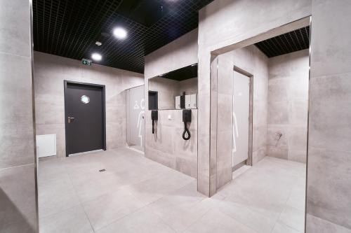 a room with a restroom with a refrigerator and a door at Polanica Park - LAGUNA - PREMIUM in Polanica-Zdrój