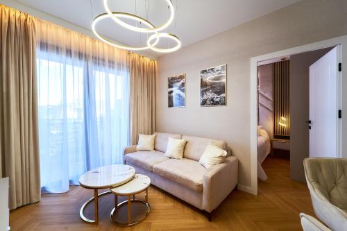 a living room with a couch and a table at Polanica Park - LAGUNA - PREMIUM in Polanica-Zdrój