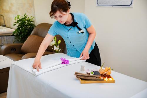 a woman standing over a table with a white table cloth at Pearl River Hotel in Hai Phong