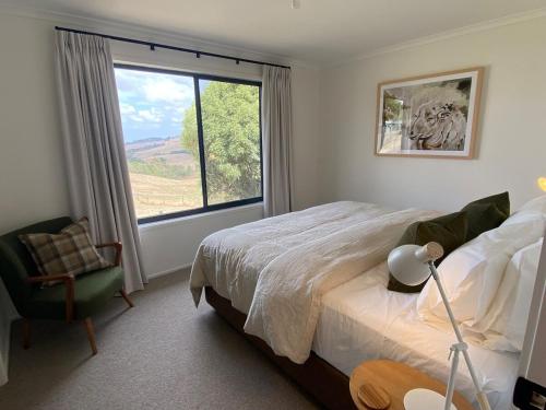 une chambre avec un lit et une grande fenêtre dans l'établissement Oak Vue cottage, à Korumburra