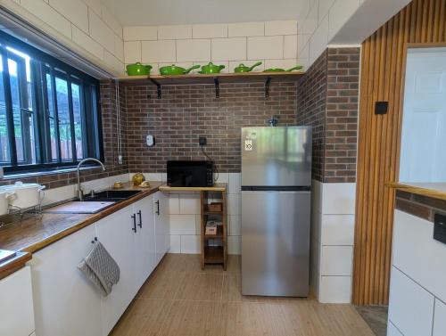 a kitchen with a stainless steel refrigerator in it at Serene farmhouse in Ministers Quarters in Mobushipe