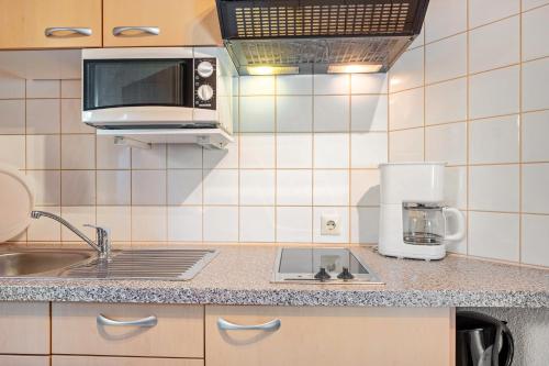 a small kitchen with a sink and a microwave at Gästehaus Gaby in Bad Bellingen