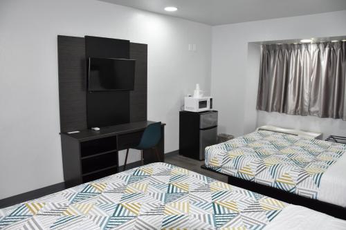 a hotel room with two beds and a desk at Motel 6 Idabel, OK in Idabel