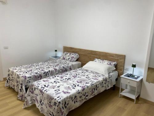 Un dormitorio con dos camas y una mesita de noche. en Veyana House, en Verona