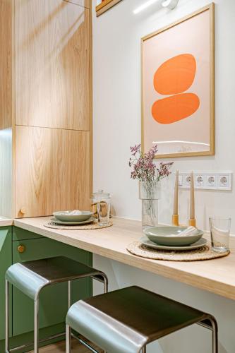 a kitchen with a counter with plates and stools at Castle District Design Studio in Budapest