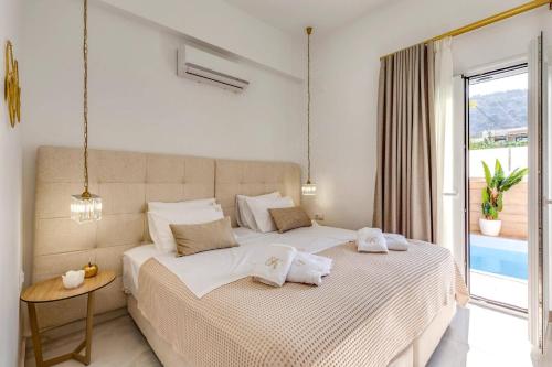 a bedroom with a bed with towels on it at Villa Karteris by Villa Plus in Stalida