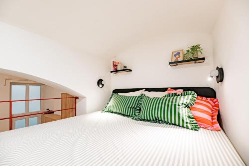 a bedroom with a bed with green and orange pillows at Castle District Design Studio in Budapest
