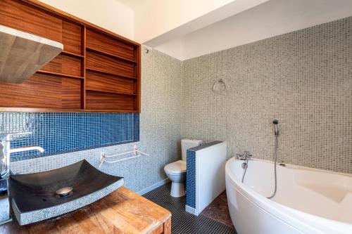 un bagno con vasca, lavandino e WC di Parad'Isula - Avec piscine à Porticcio a Grosseto-Prugna