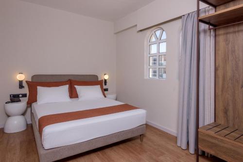 a bedroom with a large white bed and a window at Zeus Hotels Ydoria Resort in Adelianos Kampos