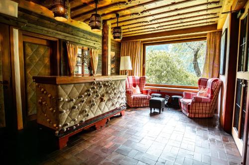 a living room with chairs and a fireplace and a window at Aparthotel Heiligenblut in Heiligenblut