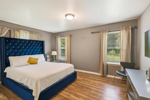 a bedroom with a bed with a blue headboard at Cozy Temple Home - Fenced Yard & Wi-Fi home in Temple