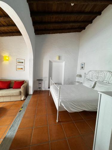 a bedroom with a bed and a couch in a room at Casa Degebe - Casas da Amieria in Amieira