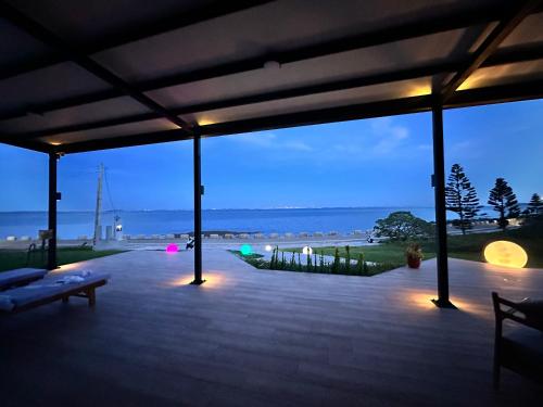 a patio with a view of the ocean at night at OLÉ Villa in Xiyu