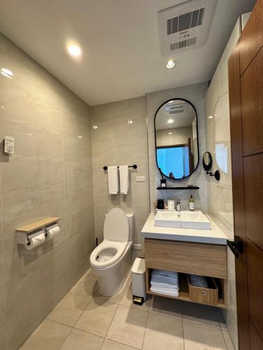 a bathroom with a toilet and a sink and a mirror at OLÉ Villa in Xiyu