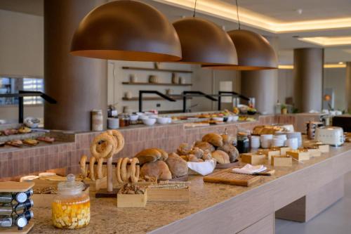 a bakery with bread and pastries on a counter at Zeus Hotels Ydoria Resort in Adelianos Kampos