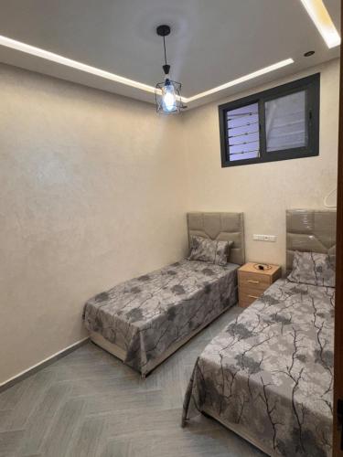 a bedroom with two beds and a ceiling fan at New luxury apartment in Martil