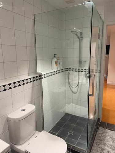 a bathroom with a toilet and a glass shower at Central City Haven in Auckland