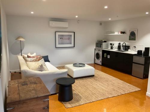a living room with a white couch and a kitchen at Central City Haven in Auckland