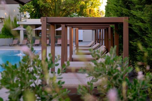 a wooden gazebo with stairs next to a pool at Zeus Hotels Ydoria Resort in Adelianos Kampos