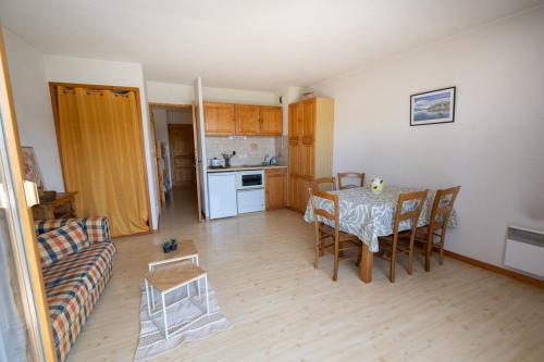 a living room with a table and a couch at Au Coin des Souvenirs in Malbuisson