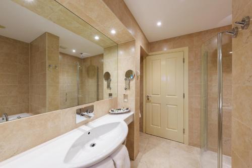 a bathroom with a tub and a sink and a mirror at Morston Hall in Holt